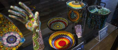 A display of colorful ceramic kitchenware with lids and handles.