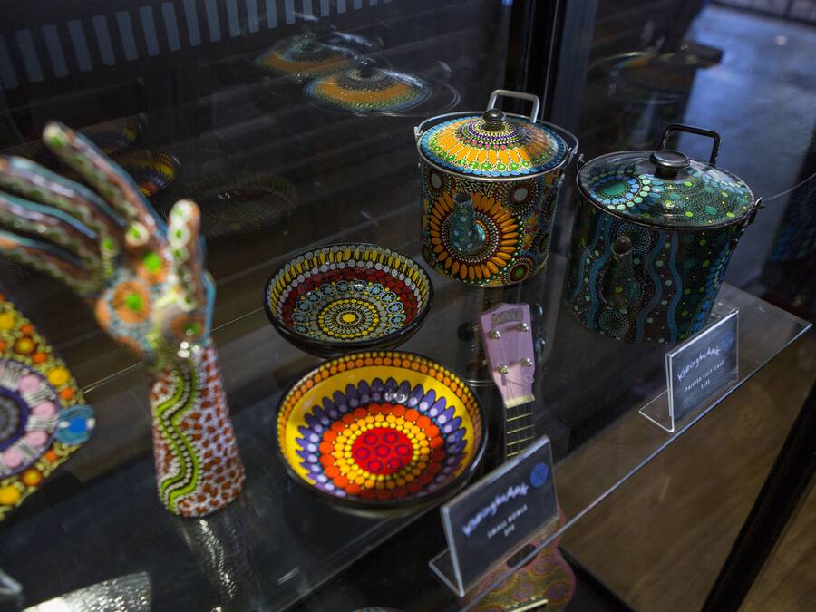 A display of colorful ceramic kitchenware with lids and handles.