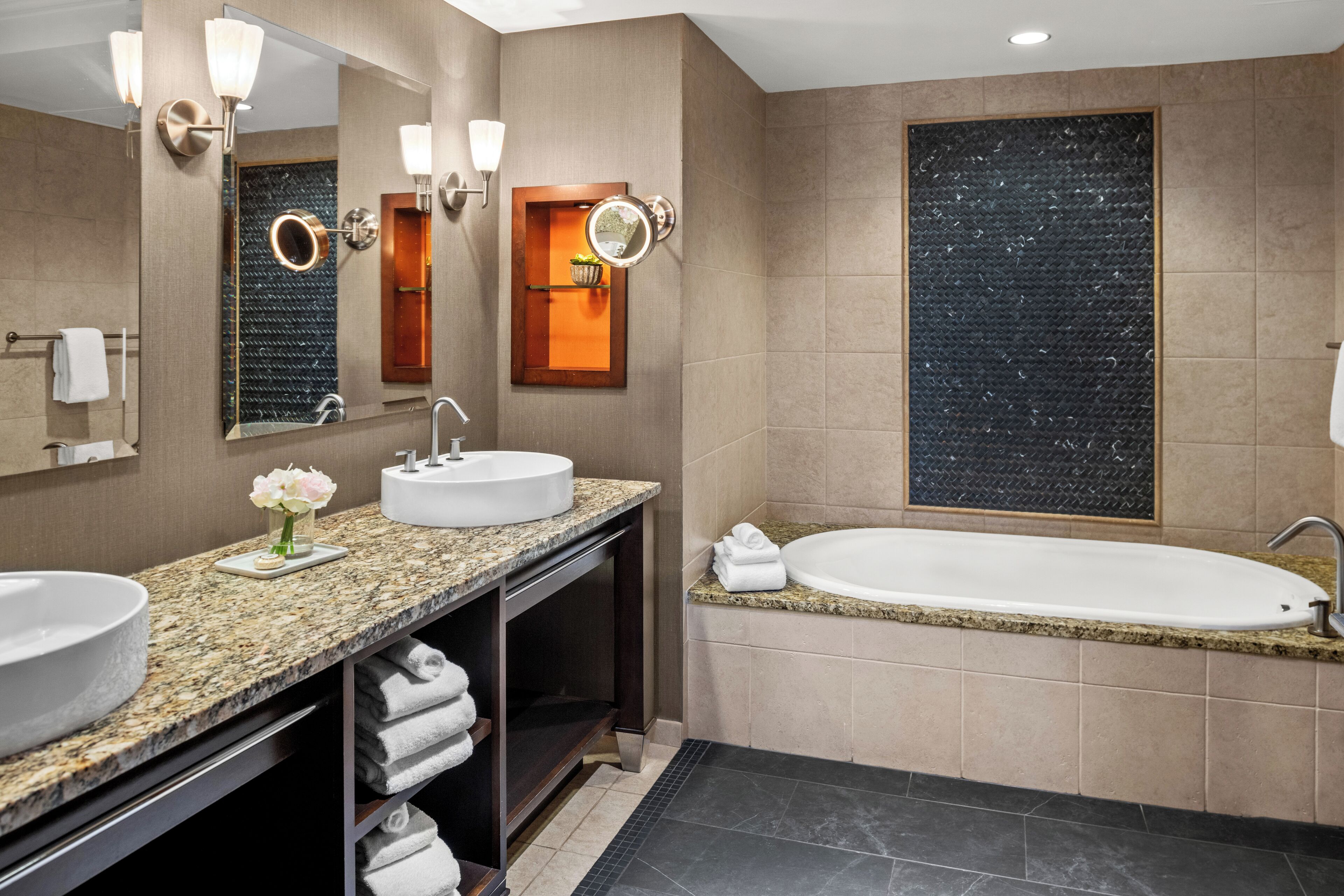 A modern bathroom with a double sink vanity, a large mirror, and a freestanding bathtub.