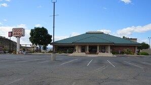 A Chuck E. Cheese's restaurant with a green roof and a parking lot in front. - America's Best Inn & Suites St. George (St. George)
