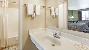 Un baño con un lavamanos grande, un espejo y una cortina de ducha.