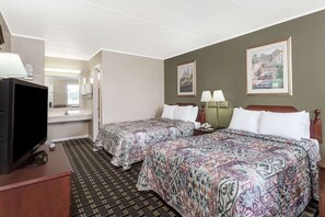 Habitación de hotel con dos camas, televisión, escritorio y baño.