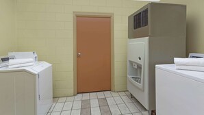 Un lavadero con una puerta, una lavadora y una secadora.