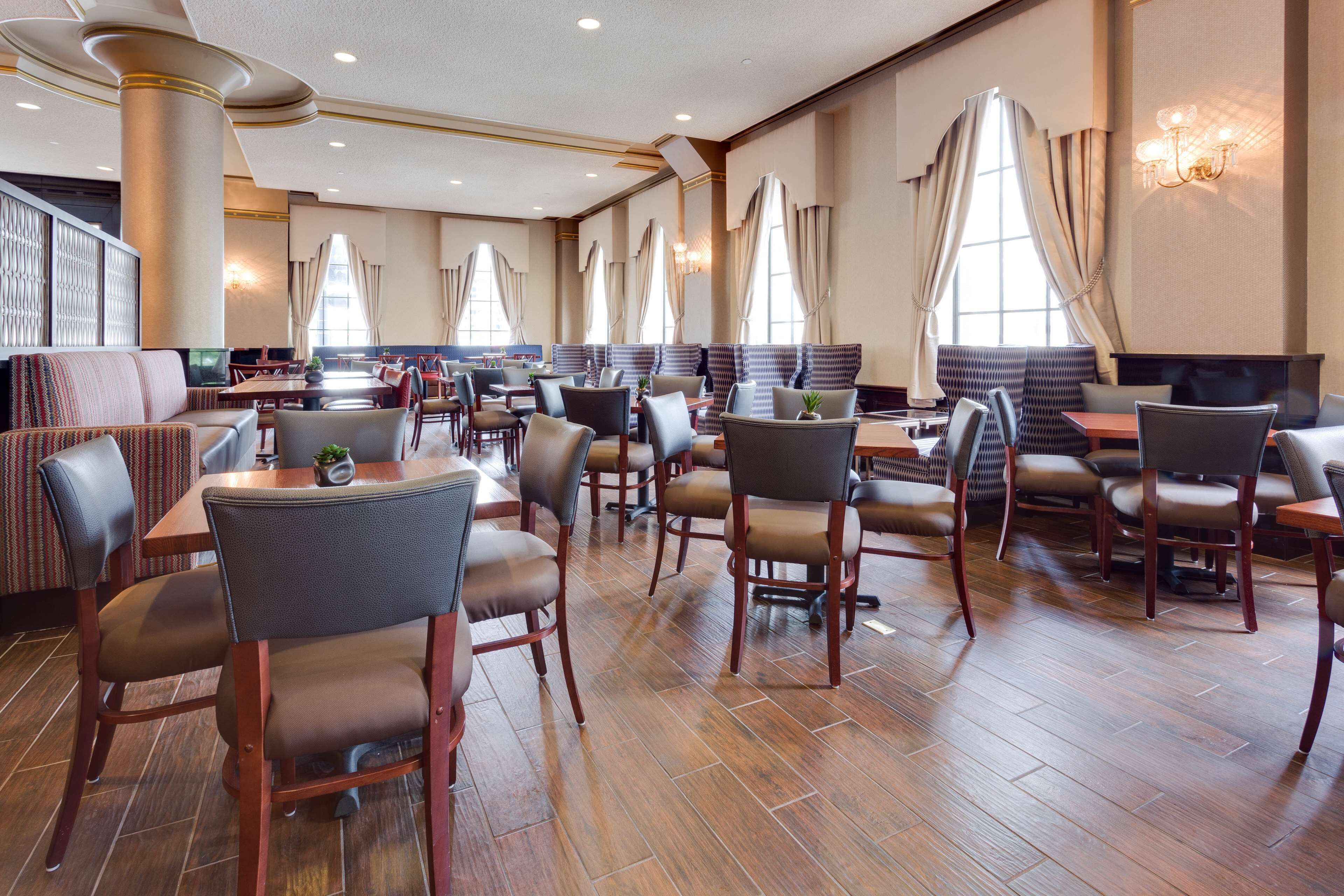 A spacious restaurant with high ceilings, wooden flooring, and a mix of booth and table seating.