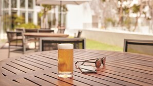 A round wooden table with a glass of beer, a pair of sunglasses, and a wallet. - Fairfield Inn & Suites Dulles Airport Chantilly (Chantilly)