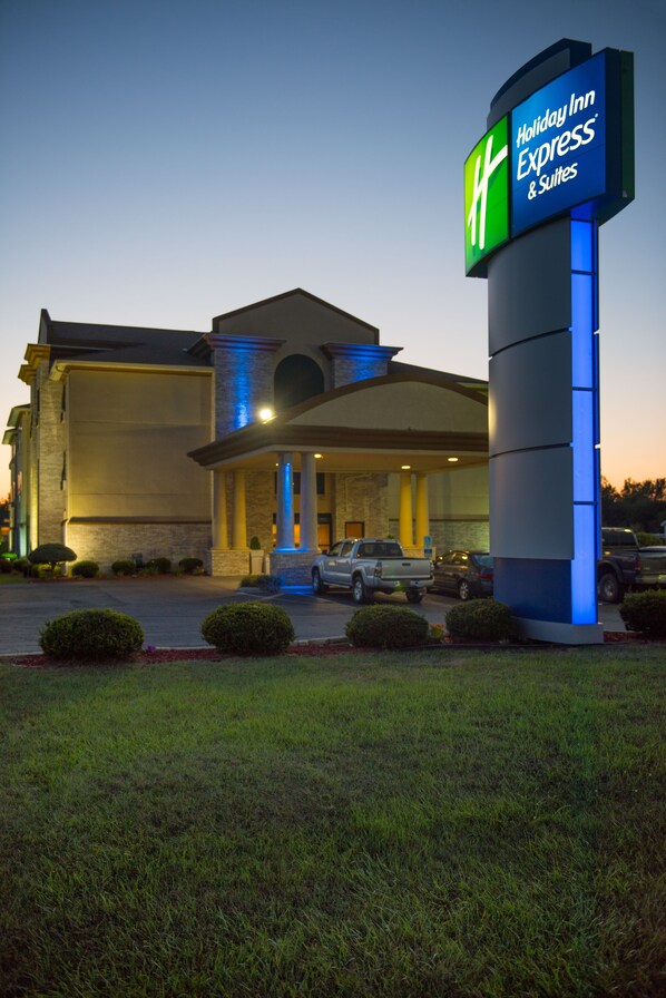 A Holiday Inn Express & Suites with a prominent sign, a covered entrance, and a parking lot with vehicles. - Holiday Inn Express & Suites Wauseon by IHG (Wauseon)