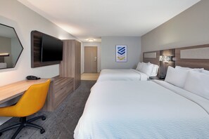 A hotel room with two beds, a desk with a chair, a television, and a door leading to another room. - Holiday Inn Express & Suites Wauseon by IHG (Wauseon)