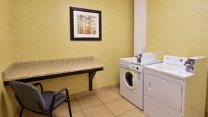 A laundry area with a bench, a chair, and a washing machine. - Holiday Inn Express & Suites Wauseon by IHG (Wauseon)