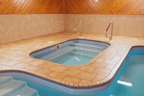 An indoor swimming pool with a tiled floor and a wooden ceiling. - Holiday Inn Express & Suites Wauseon by IHG (Wauseon)