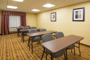 A conference room with multiple tables and chairs, a large window with curtains, and two framed pictures on the wall. - Holiday Inn Express & Suites Wauseon by IHG (Wauseon)