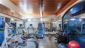 A gym with treadmills, elliptical machines, and free weights.