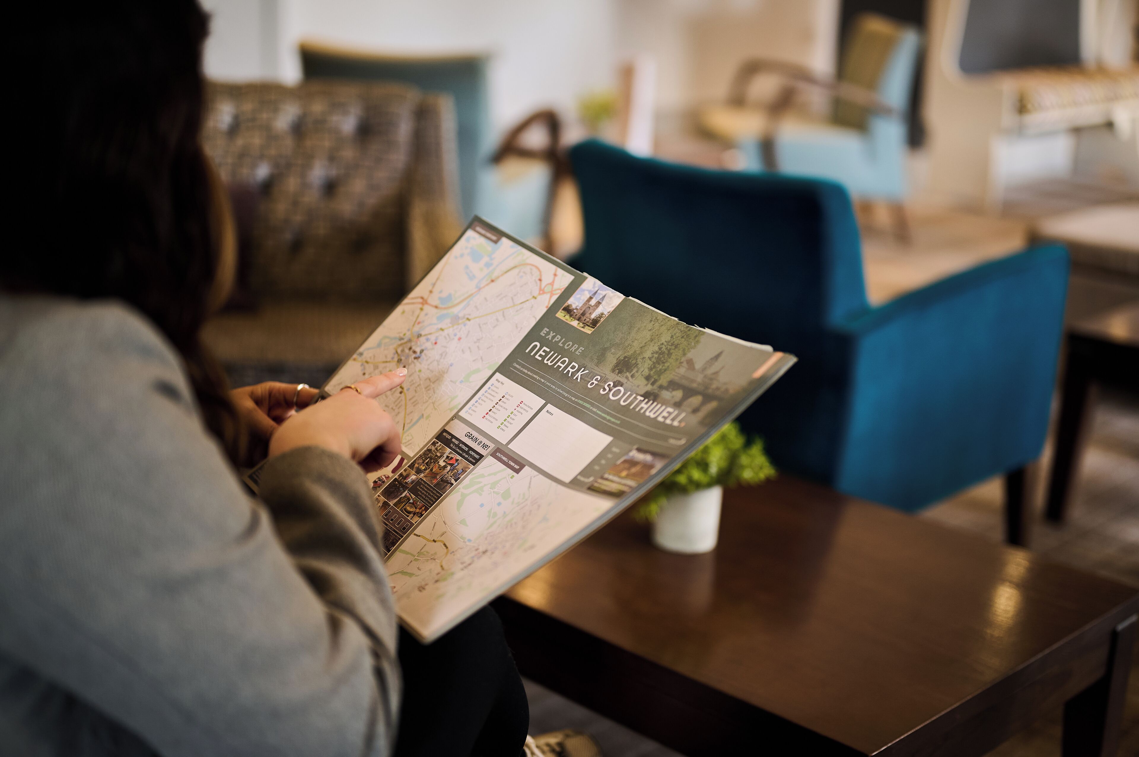 Une personne est en train de lire une brochure de voyage intitulée « Découvrez Newark et Southwell ».