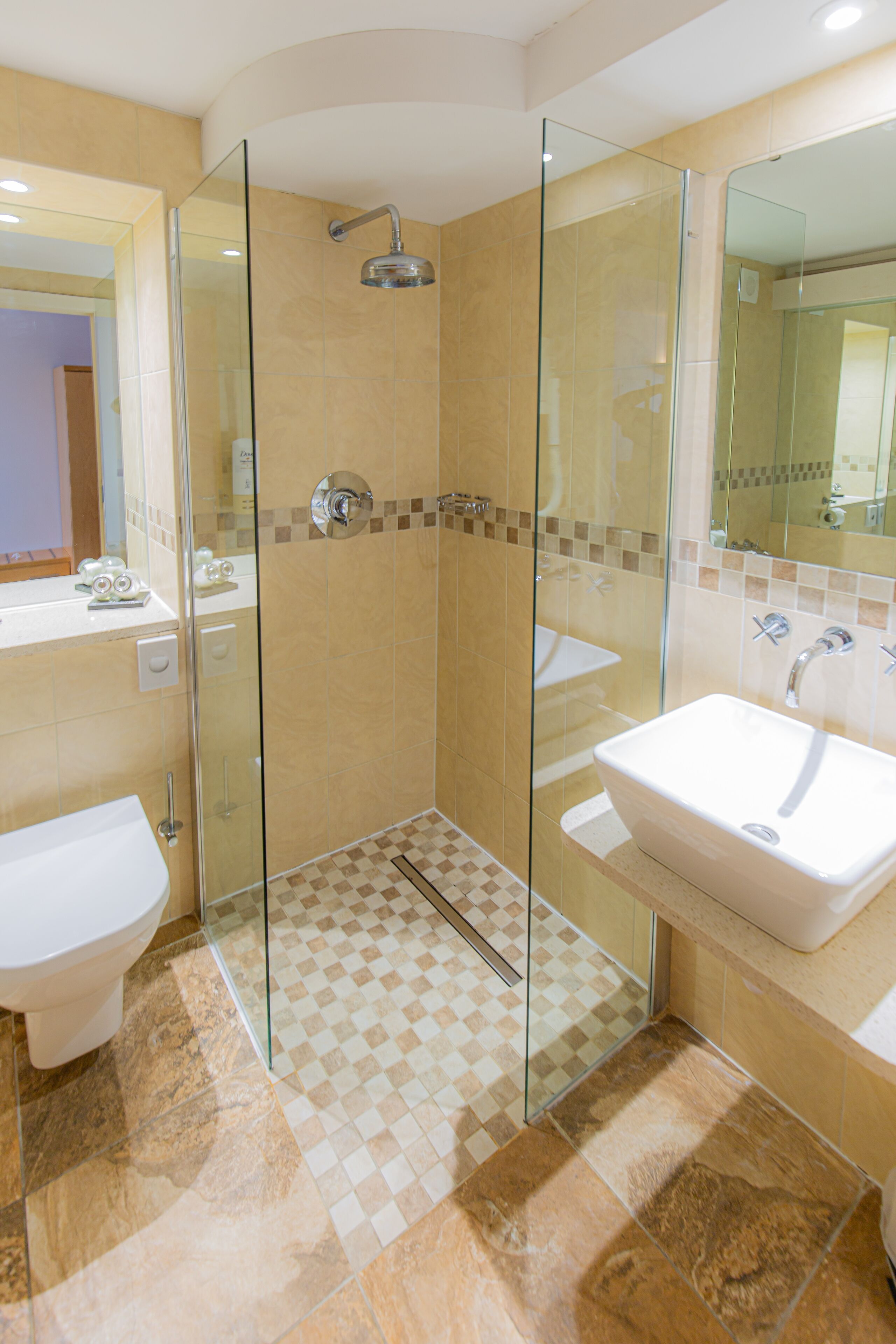 A modern bathroom with a glass-enclosed shower, two sinks, and a large mirror.