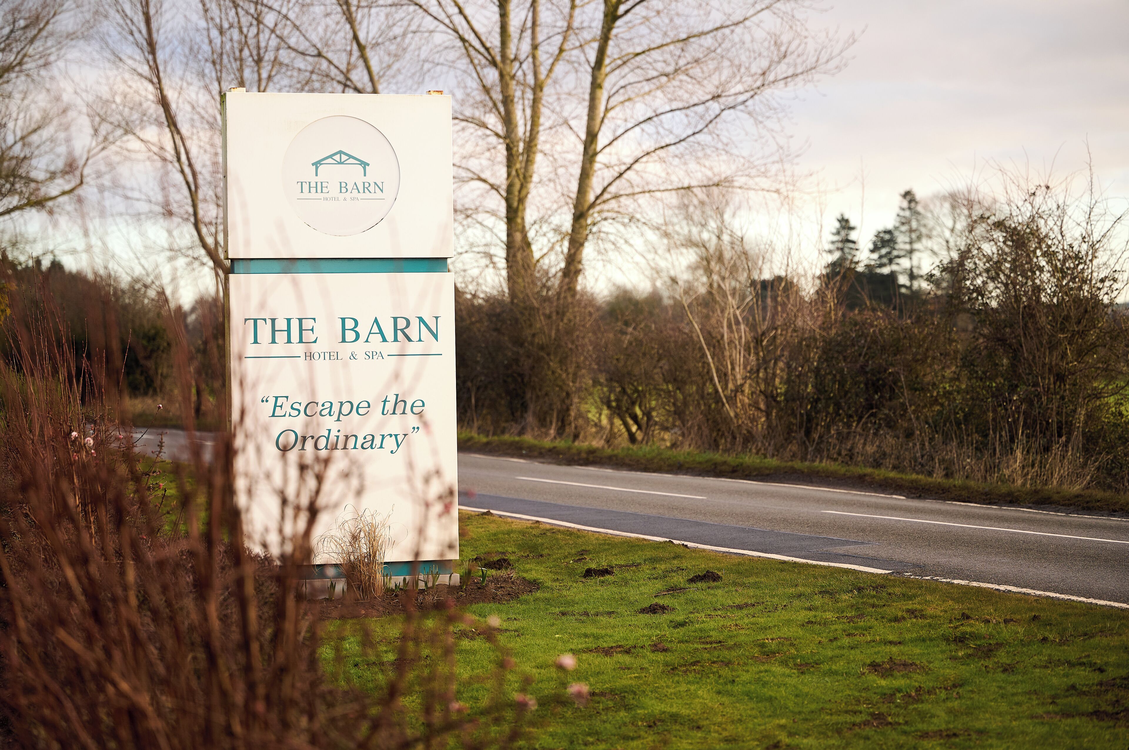 A sign for 'The Barn Hotel & Spa' with the tagline 'Escape the Ordinary'.