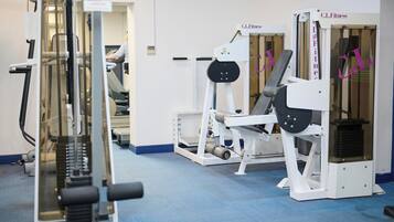 A gym with various exercise machines, including a treadmill and weight machines.