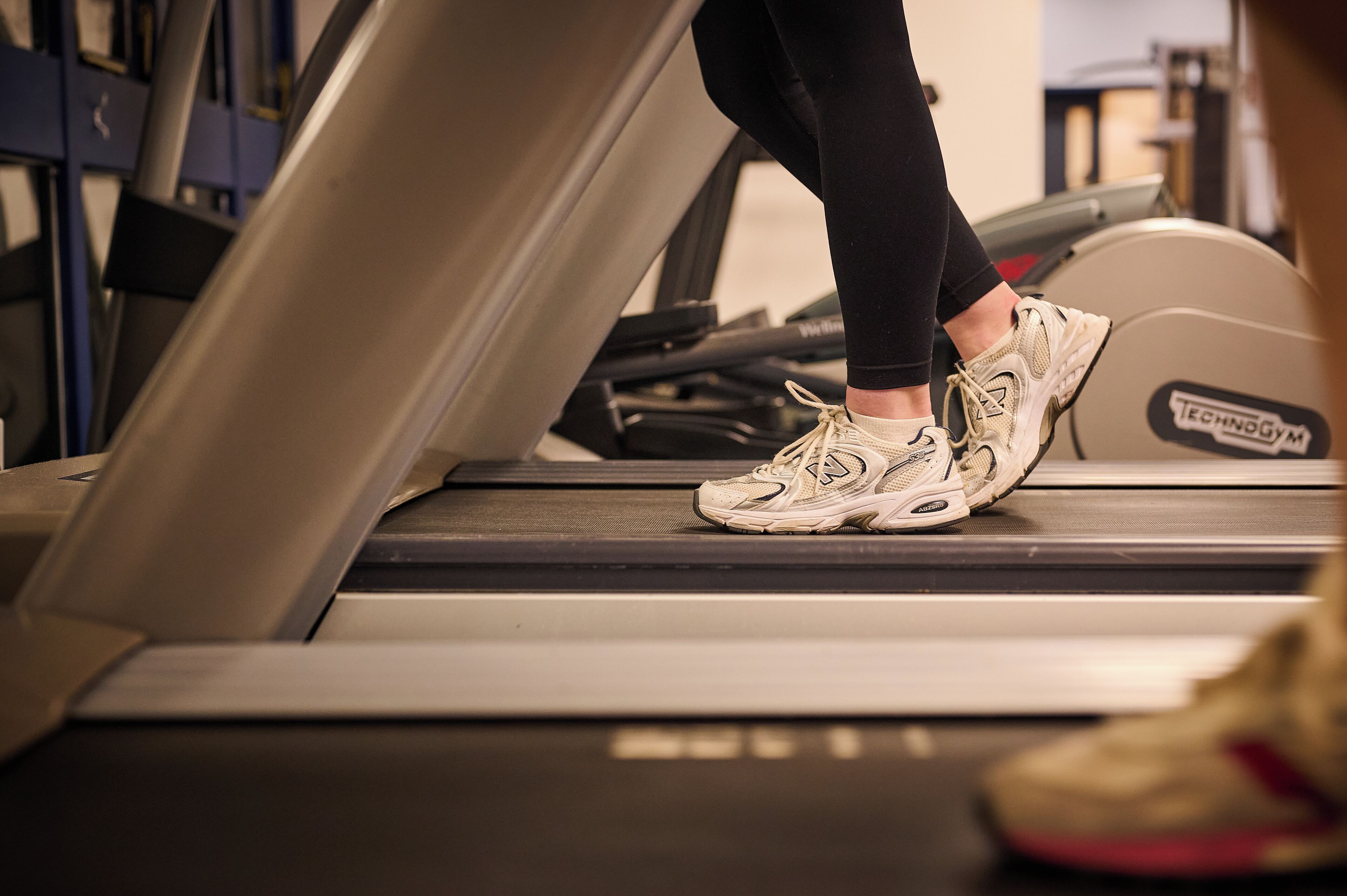 A treadmill in a gym with a visible brand label.