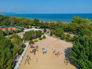 An aerial view of a beach area with a volleyball court, swings, and a playground. - Novotel Gdansk Marina (Gdansk)