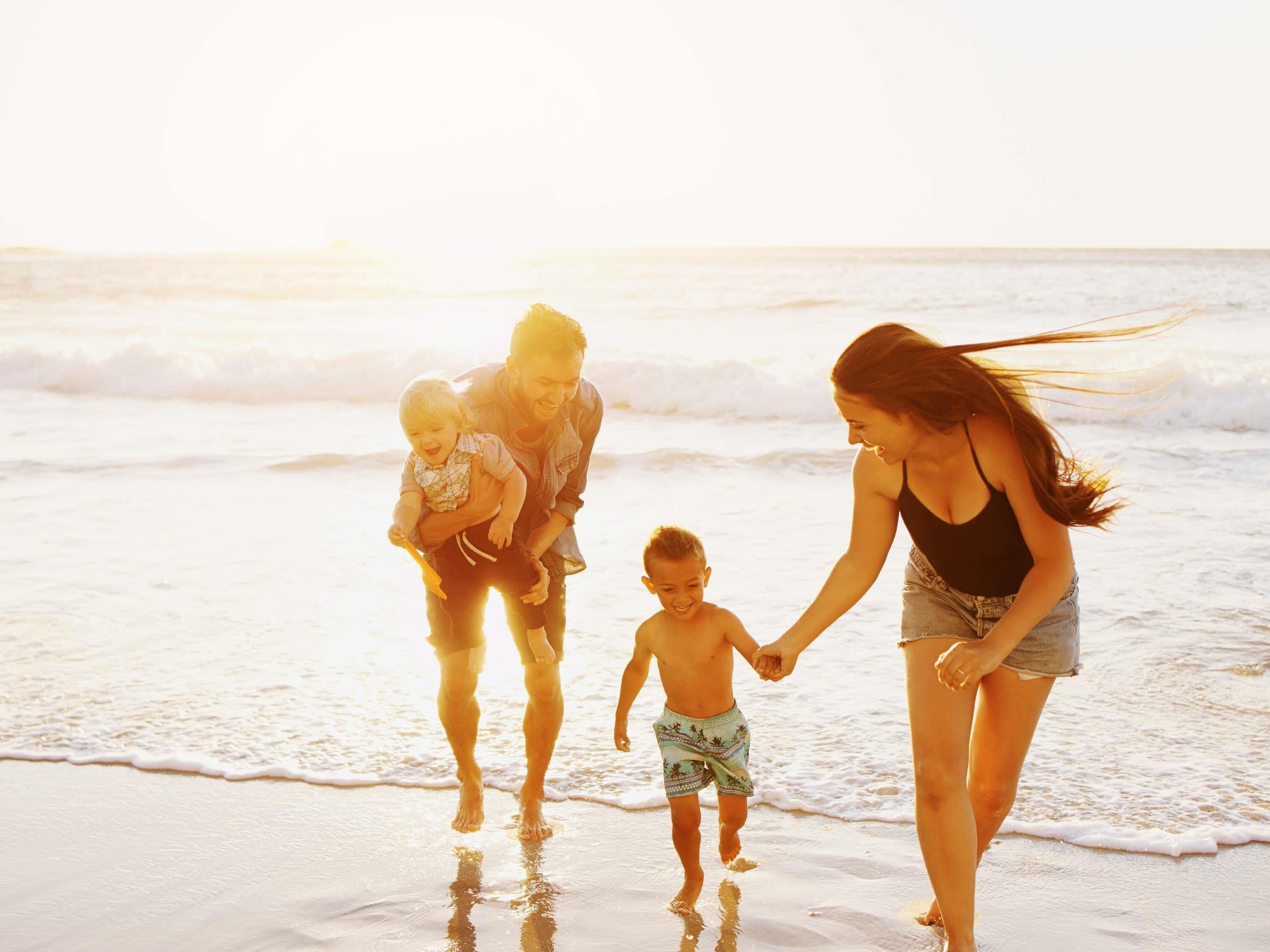 Een strand met mensen die over het zand lopen.