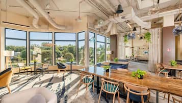 Un interior moderno con ventanas amplias, un área de comedor central y una variedad de opciones de asientos.