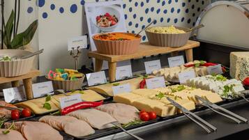 A buffet with various food items including meats, cheeses, and a bowl of salad.