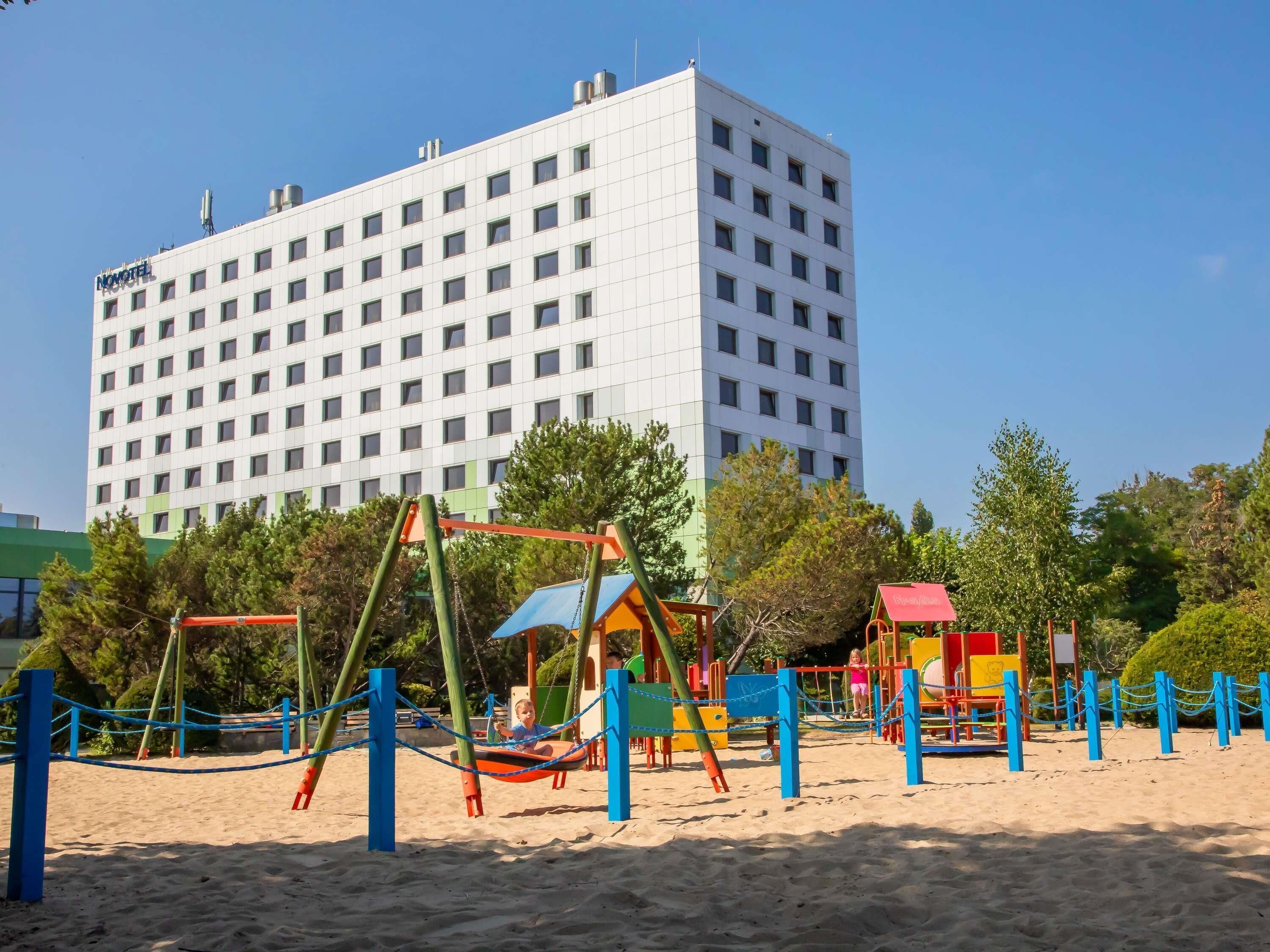 Un hotel dal design moderno, caratterizzato da un ampio edificio con molte finestre e un tetto piatto.