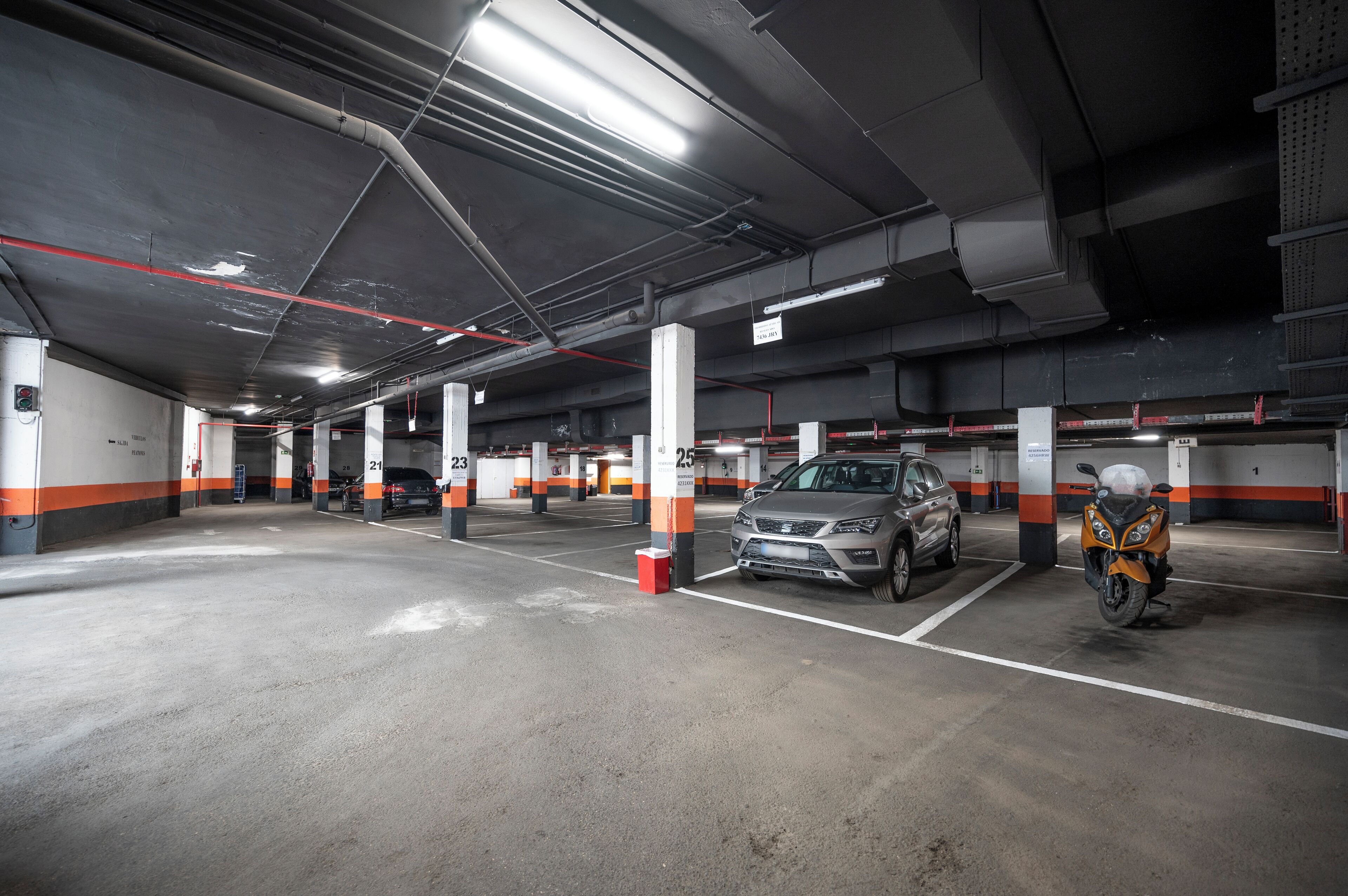 A multi-level parking garage with clearly marked parking spaces and overhead lighting.
