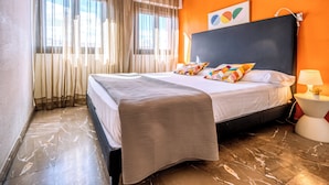 A hotel room with a bed, curtains, a lamp, and a wall with a picture. - Apartamentos G3 Galeón (Madrid)