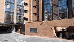 A multi-story building with large windows and a brick facade. - Apartamentos G3 Galeón (Madrid)