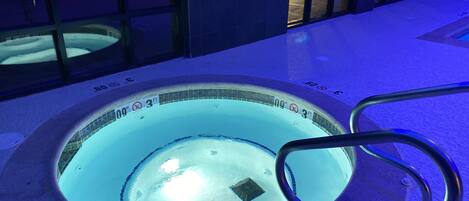 Un jacuzzi con una profundidad de 3 pies y un diámetro de 9 pies, rodeado por una terraza de baldosas.