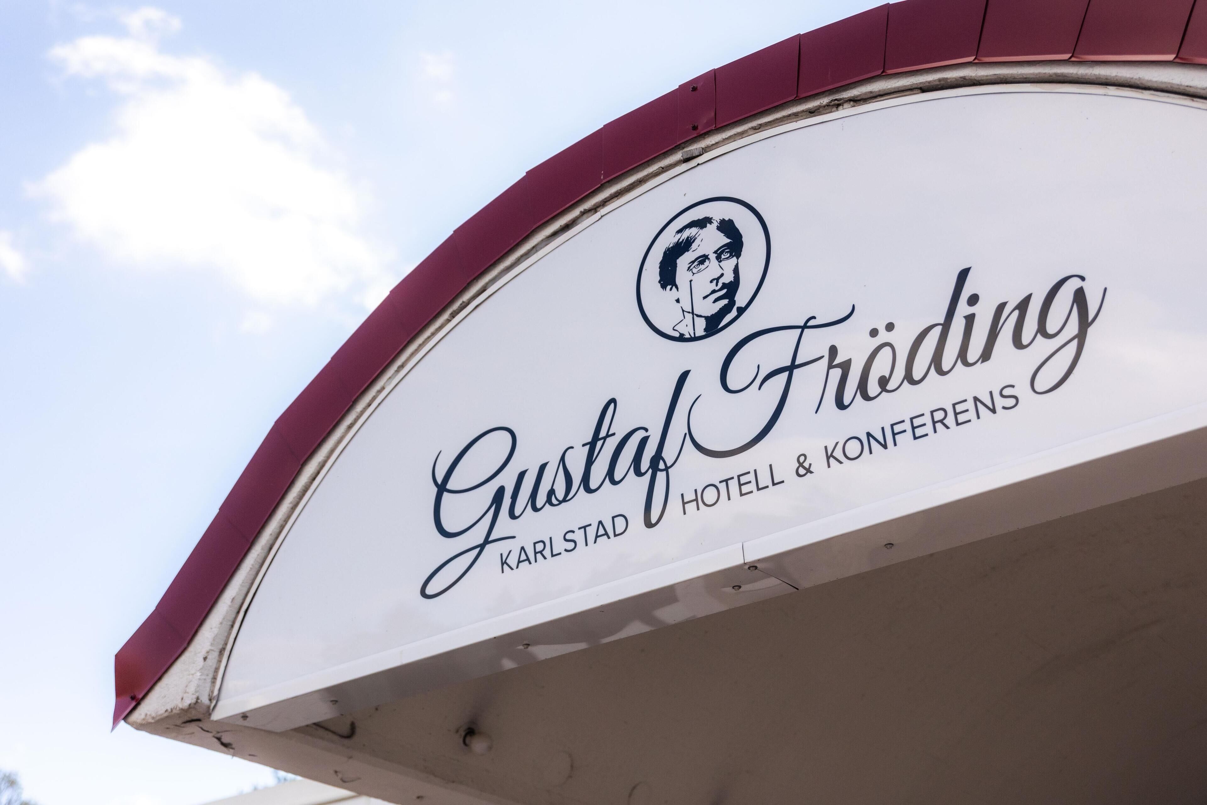 Letrero de 'Gustaf Fröding Karlstad Hotel & Conferences' con un logotipo circular encima del texto.