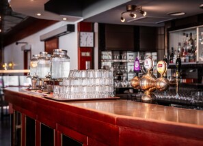 A bar area with stacked glasses, a clock, and a beer tap labeled 'GRANZWEIGER'. - Best Western Gustaf Fröding Hotel & Konferens (Karlstad)