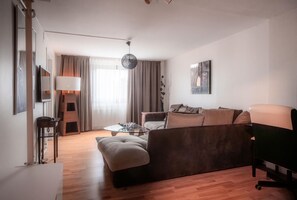 A modern living room with a sofa, a coffee table, a lamp, and a painting on the wall. - Best Western Gustaf Fröding Hotel & Konferens (Karlstad)