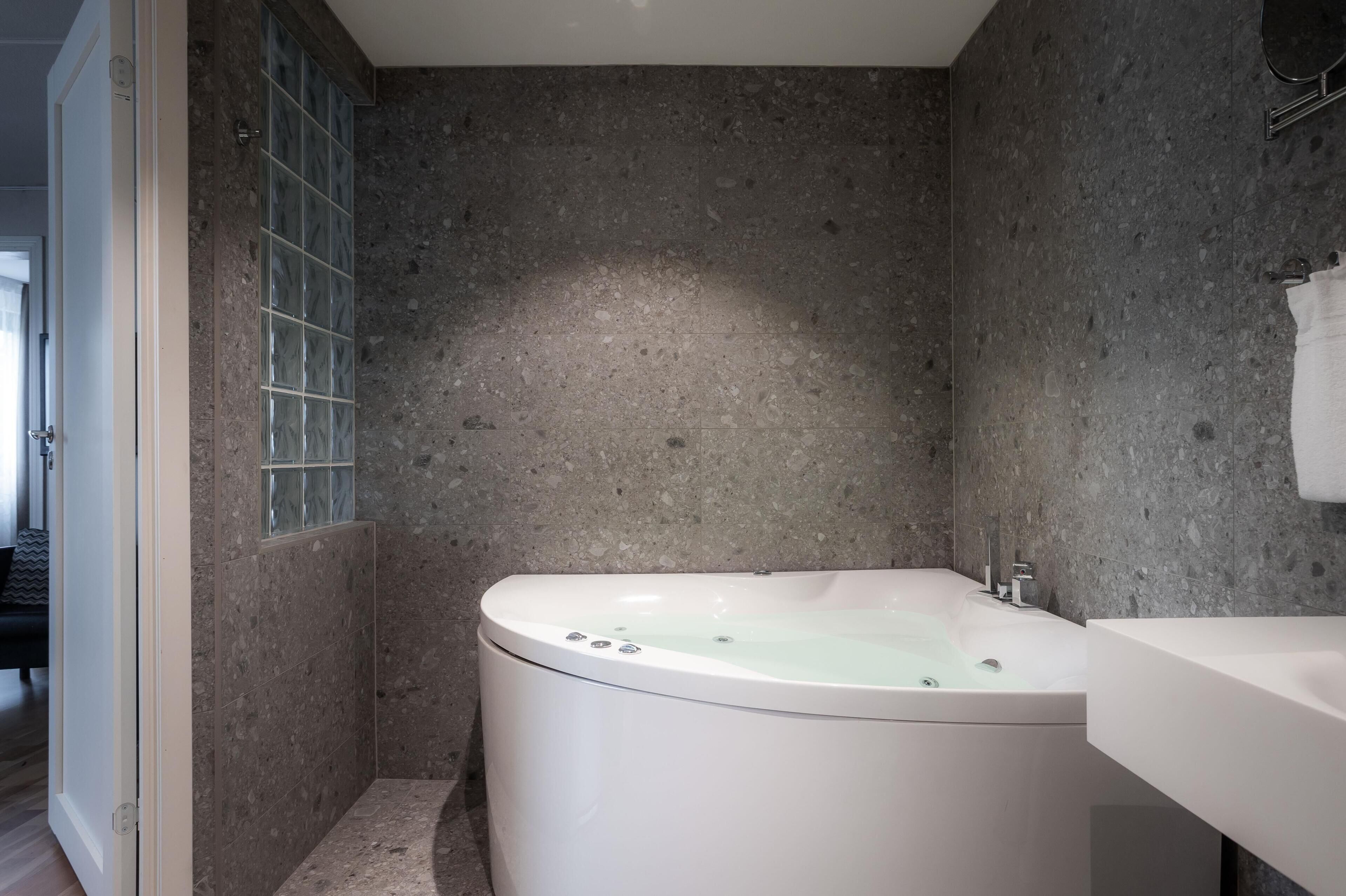 A modern bathroom with a freestanding bathtub, a glass shower enclosure, and a white sink.