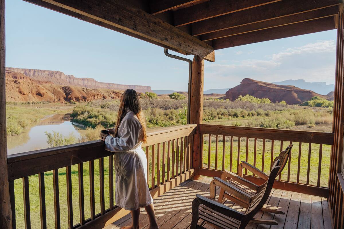 A wooden deck with a view of a river and mountains.