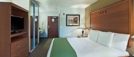 Habitación de hotel con cama, televisión, escritorio y baño.