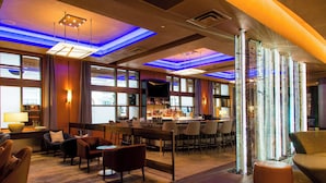 A modern hotel lobby with a bar area, seating arrangements, and large windows. - Grand Hyatt Seattle (Seattle)