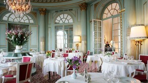 A formal dining room with multiple tables set for service, elegant chandeliers, and classical architecture. - Château d'Artigny (Montbazon)