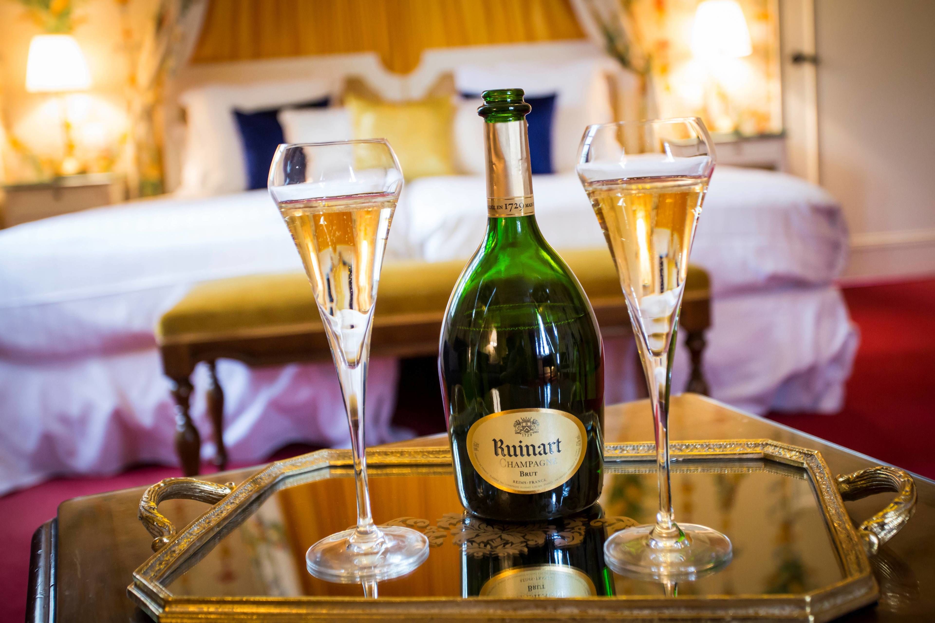 Une bouteille de champagne Ruivart sur un plateau, accompagnée de deux coupes de champagne.