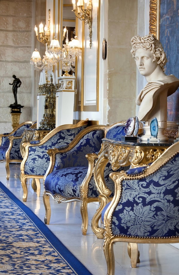 A luxurious room with ornate blue and gold furniture, a bust sculpture, and a chandelier. - Château De Beauvois - La Maison Younan (Saint-Etienne-de-Chigny)