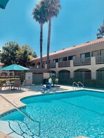 Una piscina al aire libre, sillones reclinables de piscina
