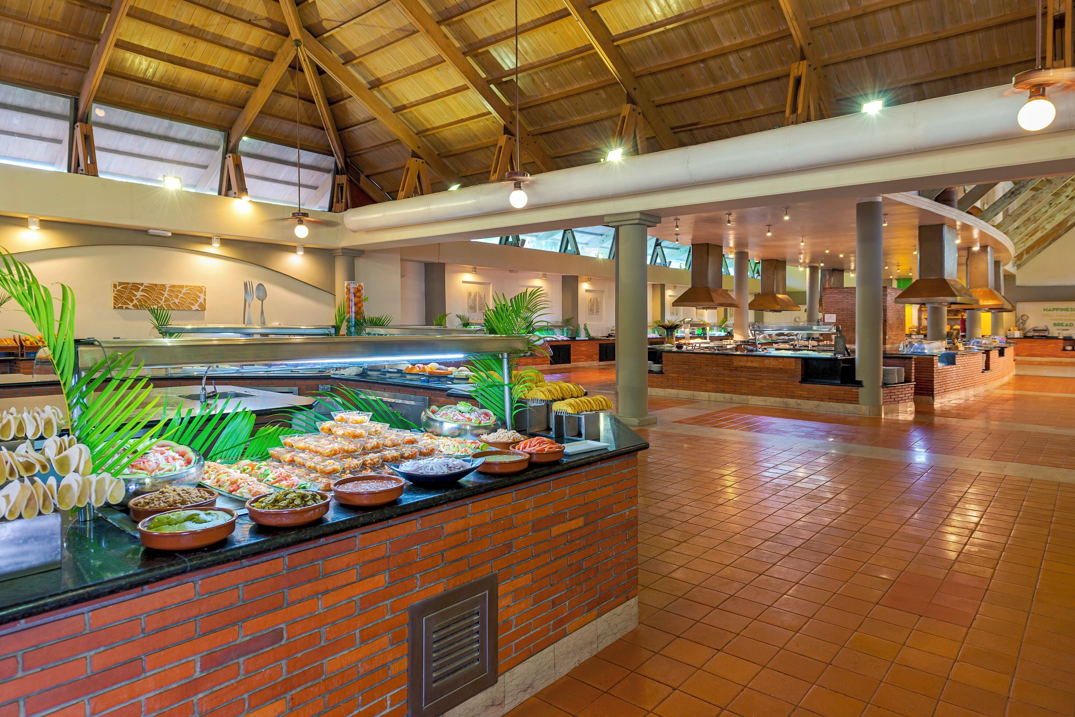 A buffet area with a variety of food items and a brick wall backdrop.