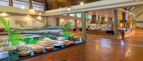 A buffet area with a variety of food items and a brick wall backdrop.