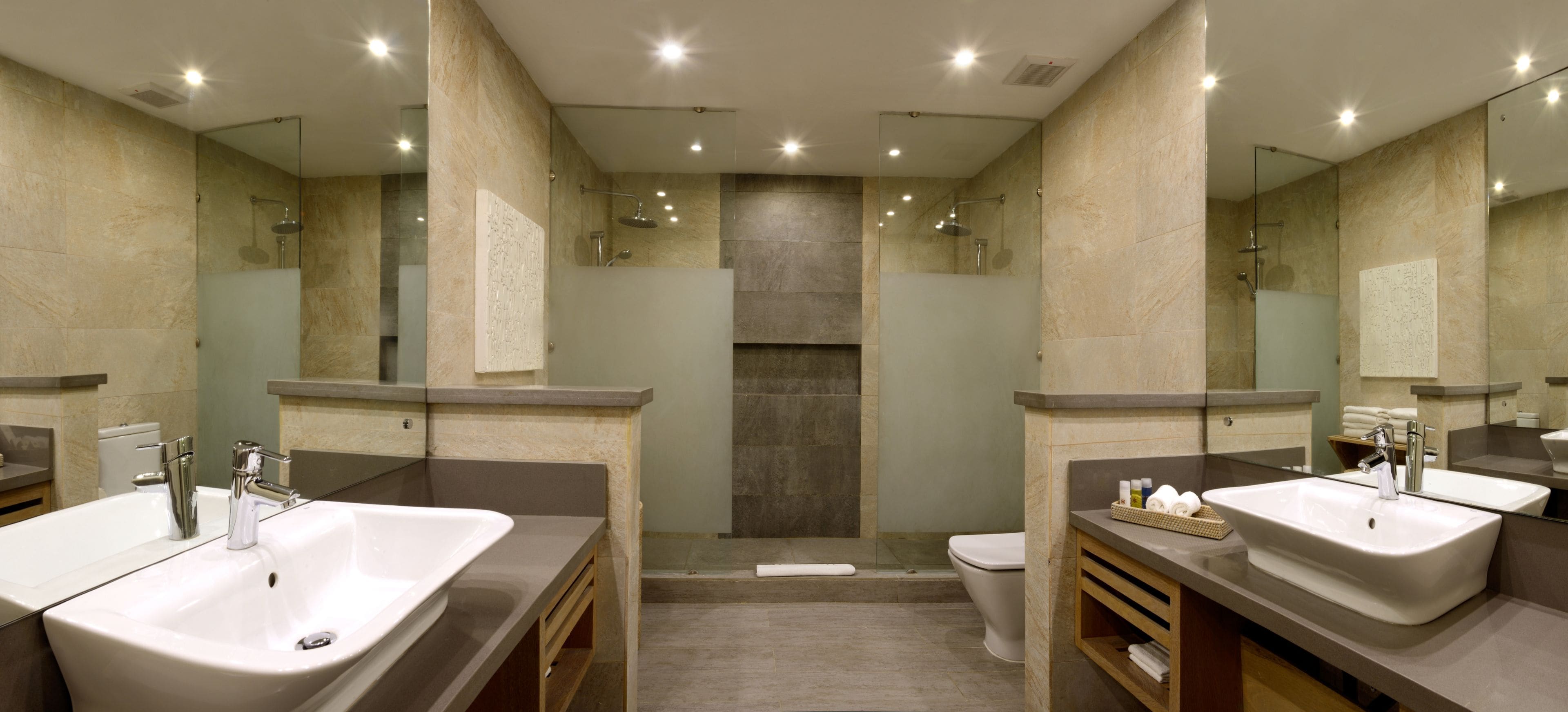 Une salle de bain moderne avec deux lavabos, une douche à l’italienne et des toilettes.