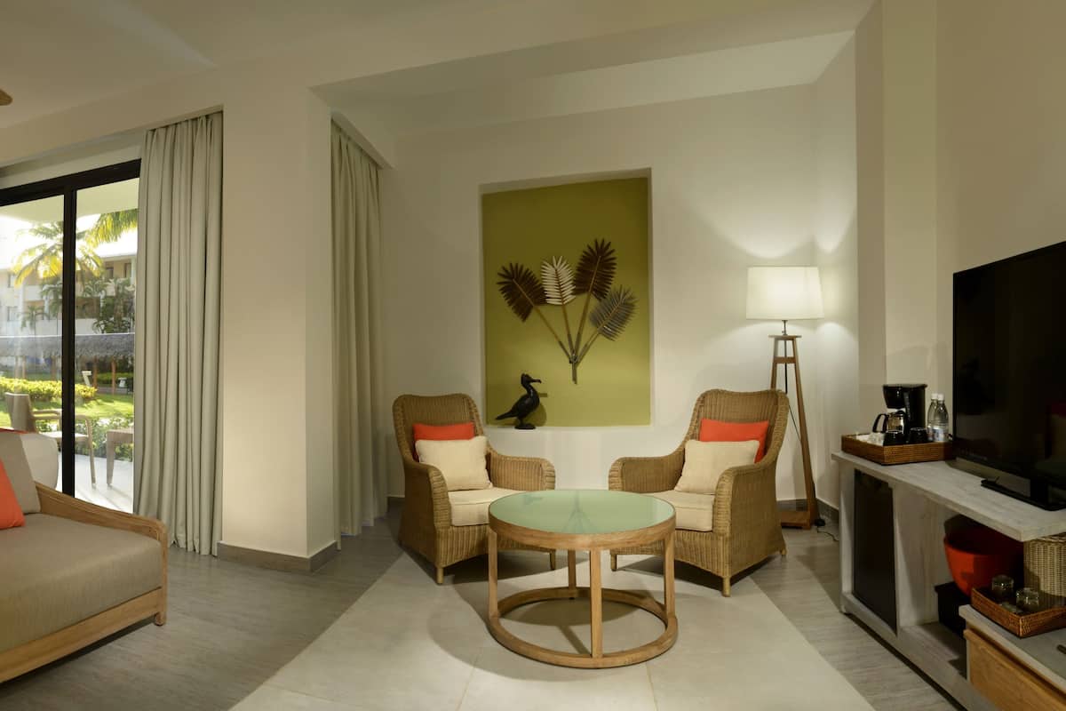 Ein Hotelzimmer mit Bett, Sofa, Fernseher, Tisch und Stuhl.