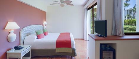 A hotel room with a bed, bedside lamps, a television, a small refrigerator, and a window with curtains.