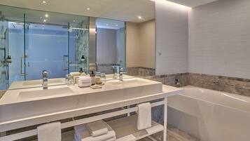 Un bagno moderno con uno specchio grande, due lavandini, una vasca e un box doccia in vetro.
