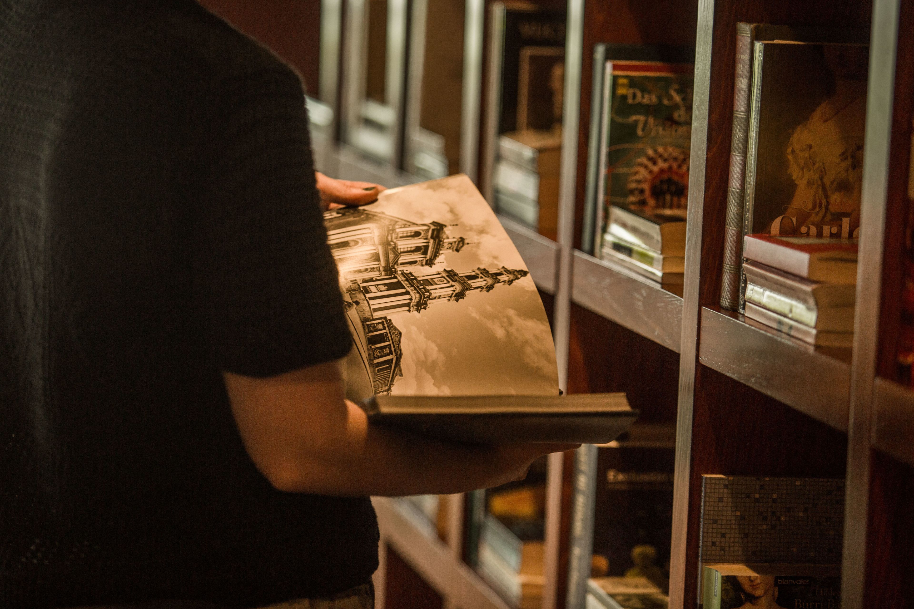 A person holding a book with a building illustration.
