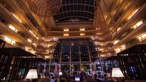 Un moderno vestíbulo de hotel con techo alto, varios pisos y un atrio central.