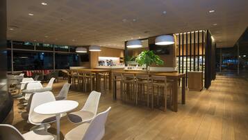 Decoração moderna com área de bar, assentos e uma planta grande.