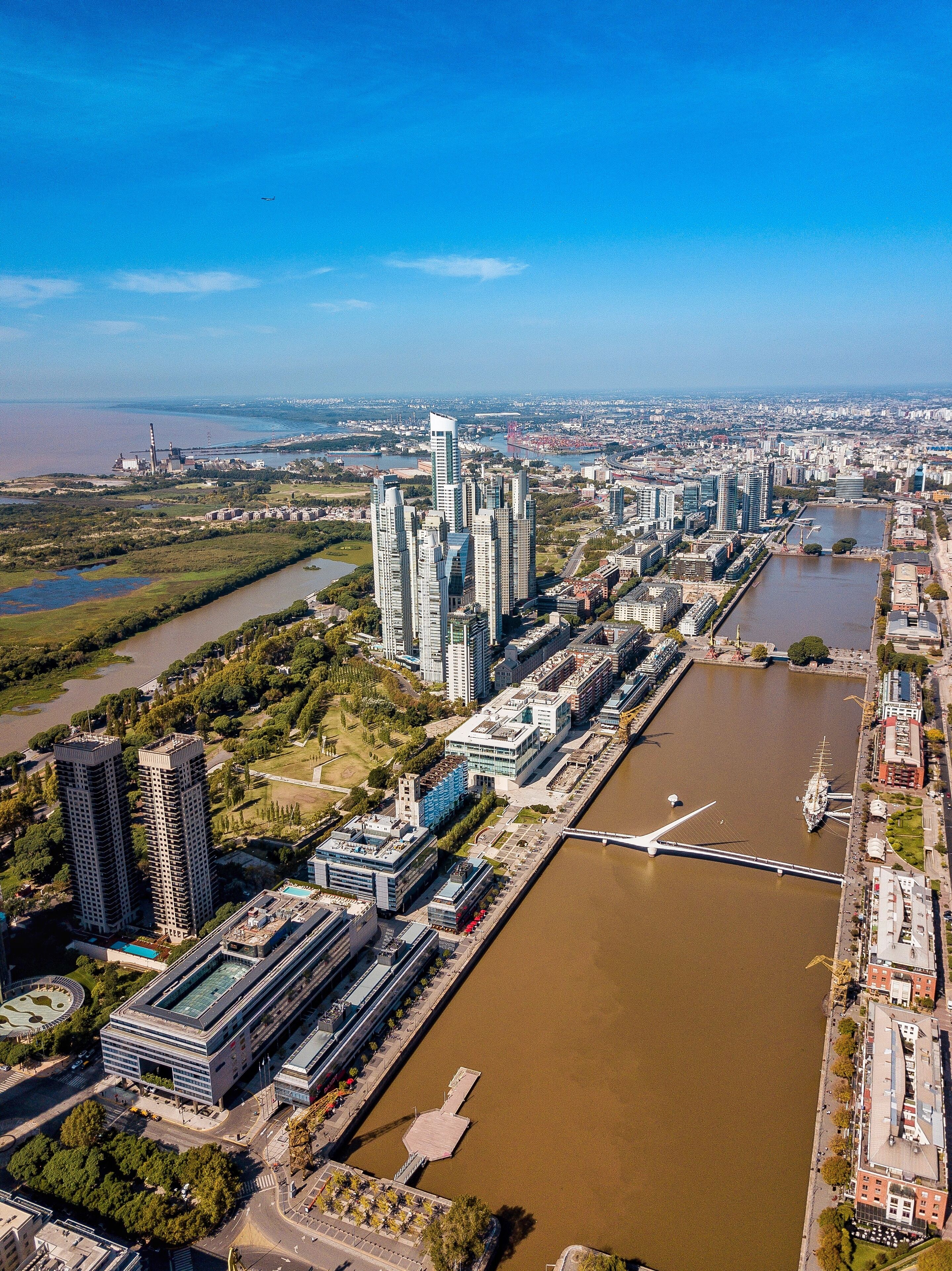 A high-rise building complex with modern architecture, a river, and a bridge.
